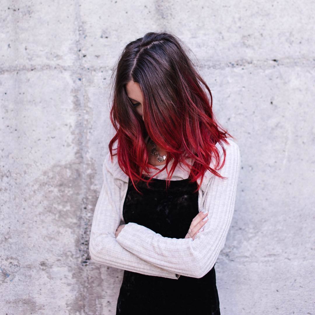 Femme de couleur marron foncé à rouge cerise fondue posant à l'extérieur