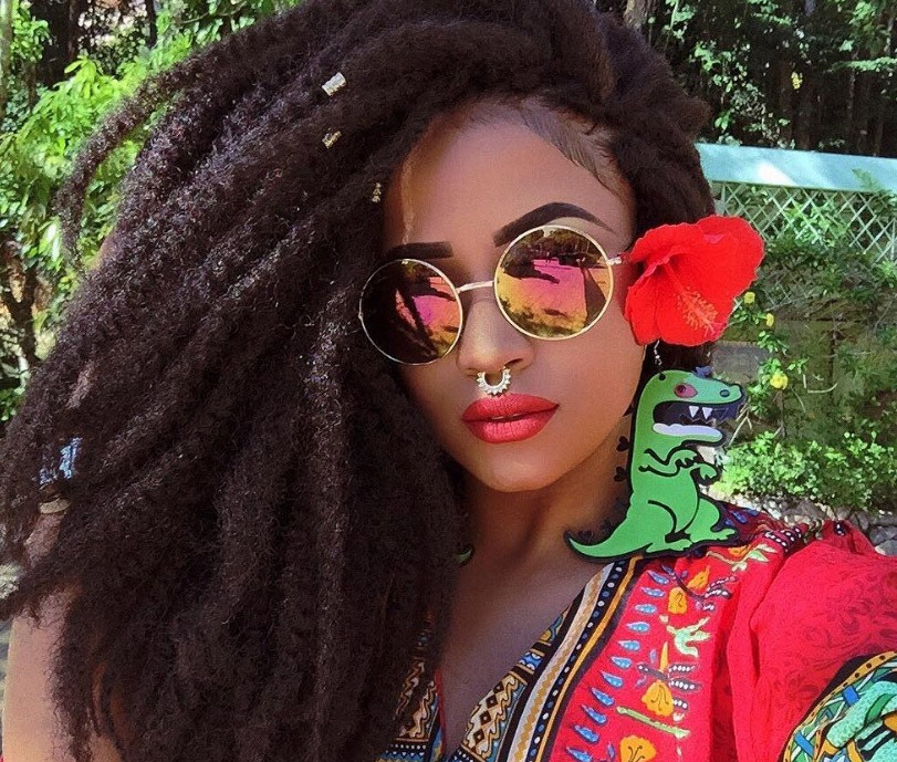 image of a woman with side swept marley twists with flowers and hair cuffs