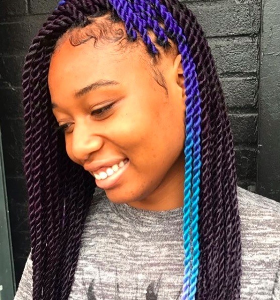 side view of a woman with marley twists and a flash of blue colour in her hair 