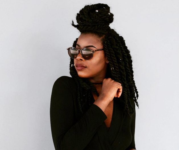 short marley twists styles: the half up half down bun hairstyle as demonstrated by addictedto.og
