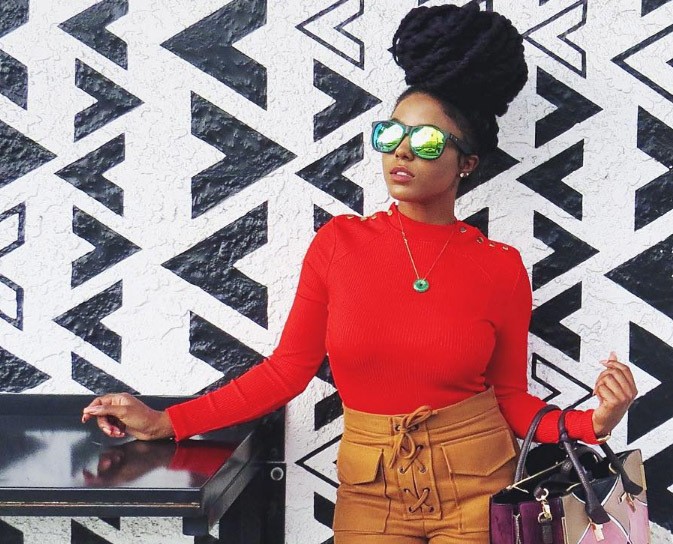 front view of a woman with a high bun updo wearing sunglasses