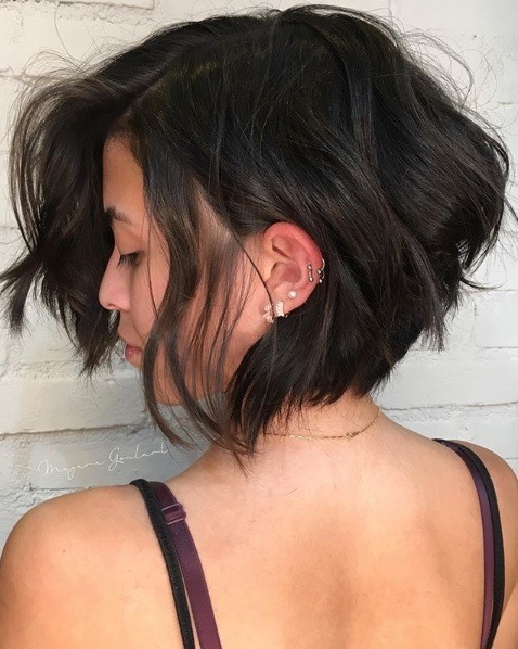 Layered bob: Back view of a woman with a dark brown graduated bob with tousled layers