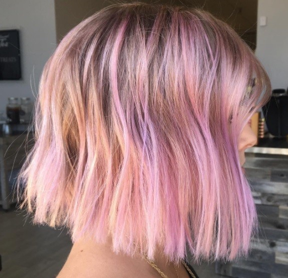 Layered bob: Side profile of a woman with a pink highlighted bob