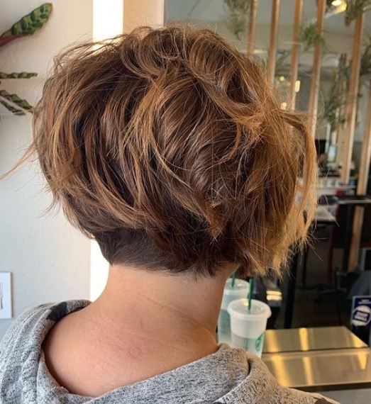 Layered bob: Back view of a woman with chestnut brown hair in a short layered bob with a shaved undercut