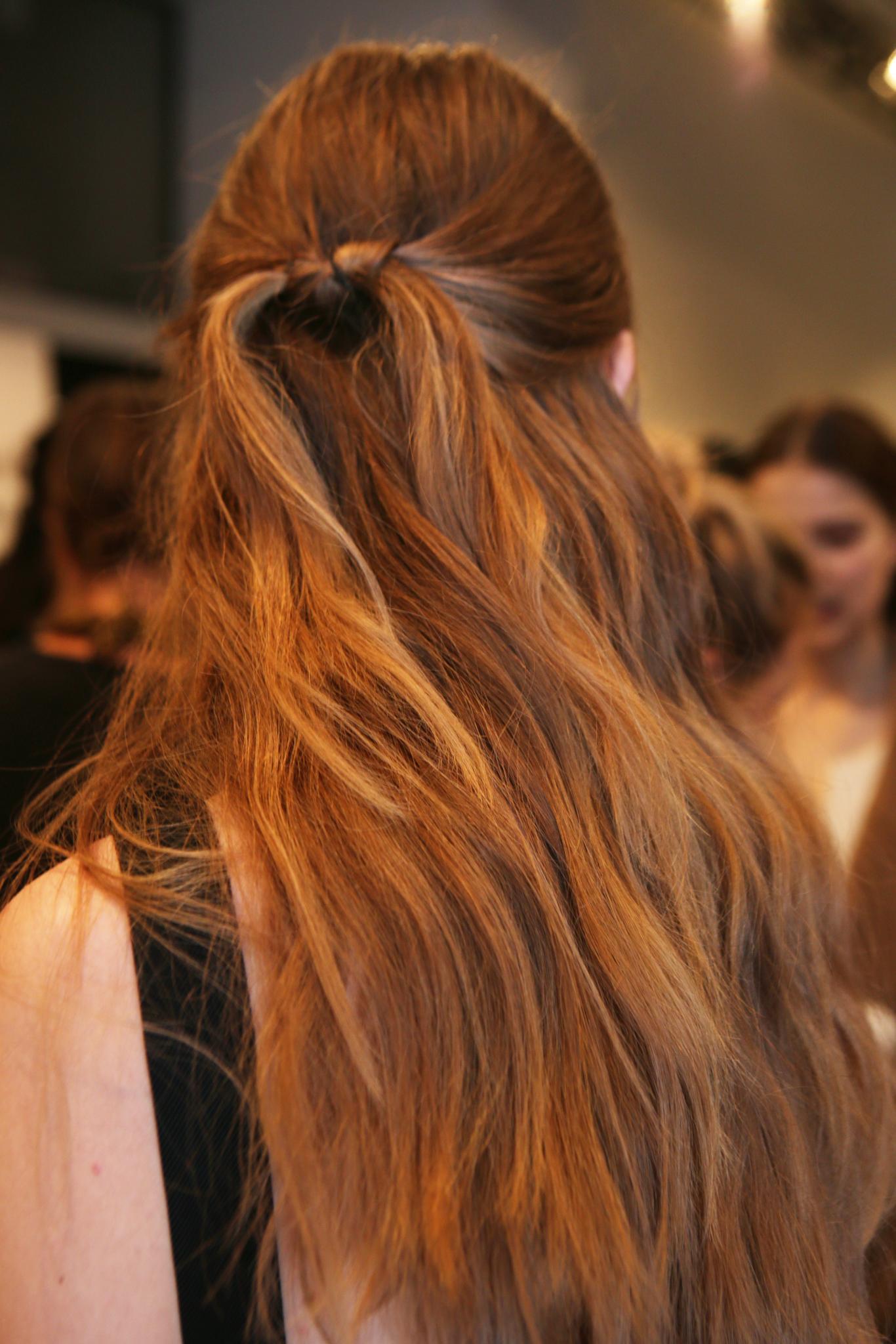 Coiffures faciles pour cheveux longs: modèle Backstage avec des cheveux longs dans une coiffure nouée mi-haut et mi-bas.