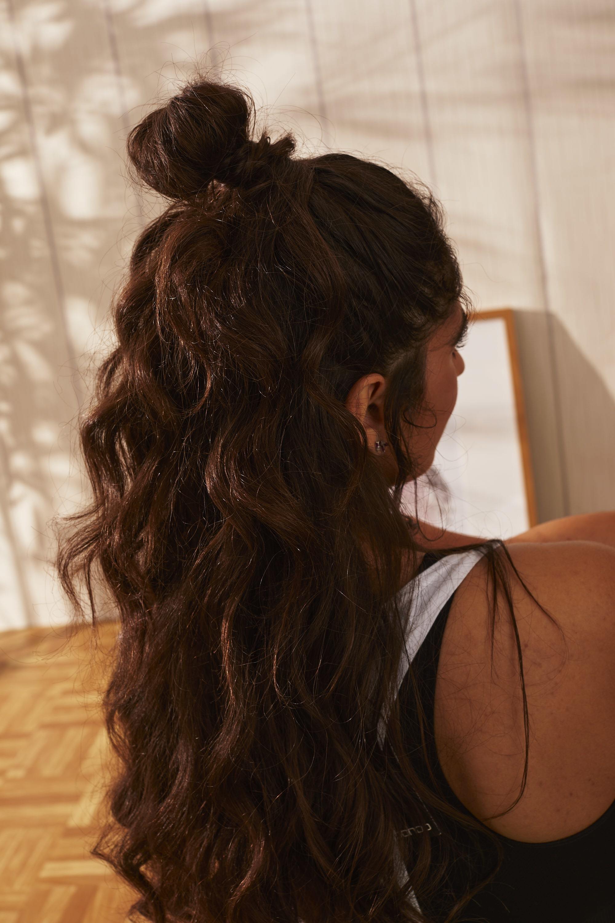 Femme aux longs cheveux noirs en forme de chignon demi-hauteur