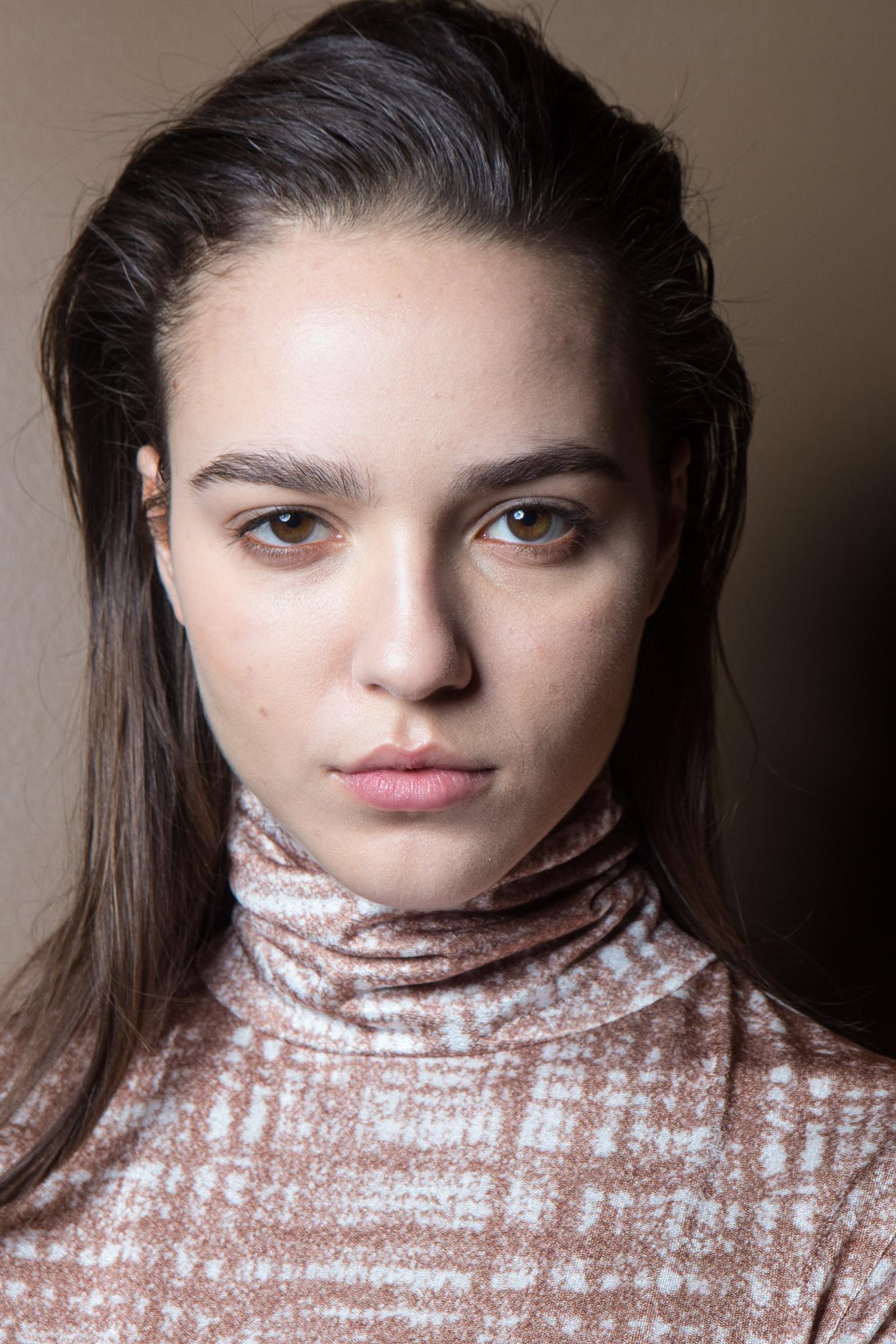 Coiffures faciles pour les cheveux longs: Femme aux longs cheveux bruns balayés sur le côté.