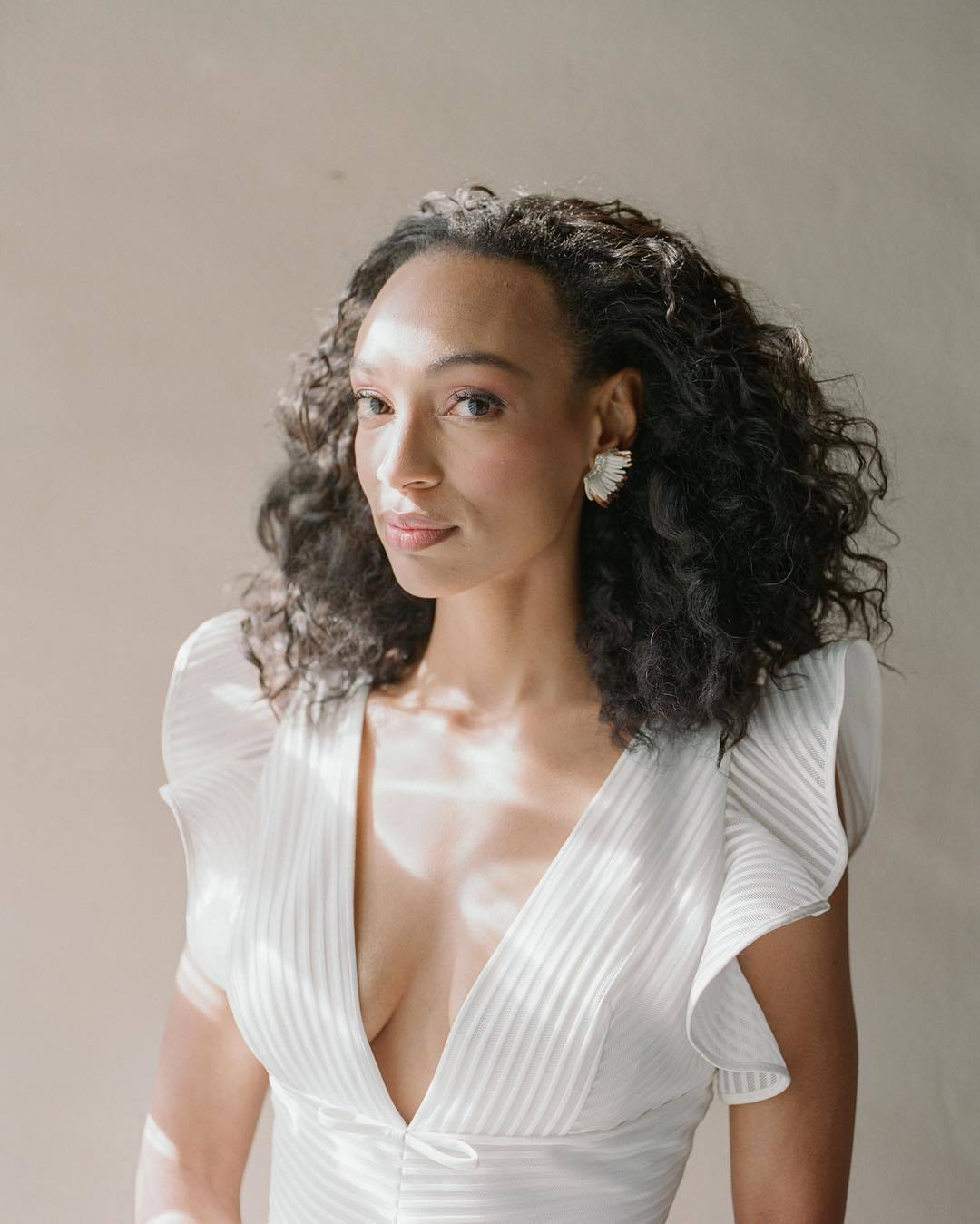 Wedding hairstyles: Woman with medium-length natural curly hair wearing it swept back