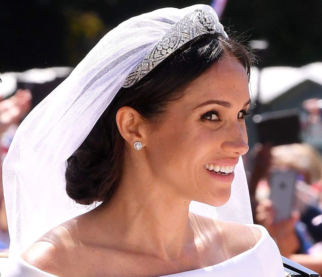 Meghan Markle Duchess of Sussex on her wedding day with her dark hair in a low messy bun with a veil and tiara