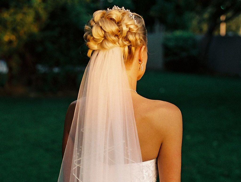 blonde bridal model with her hair in an intricate updo with a veil