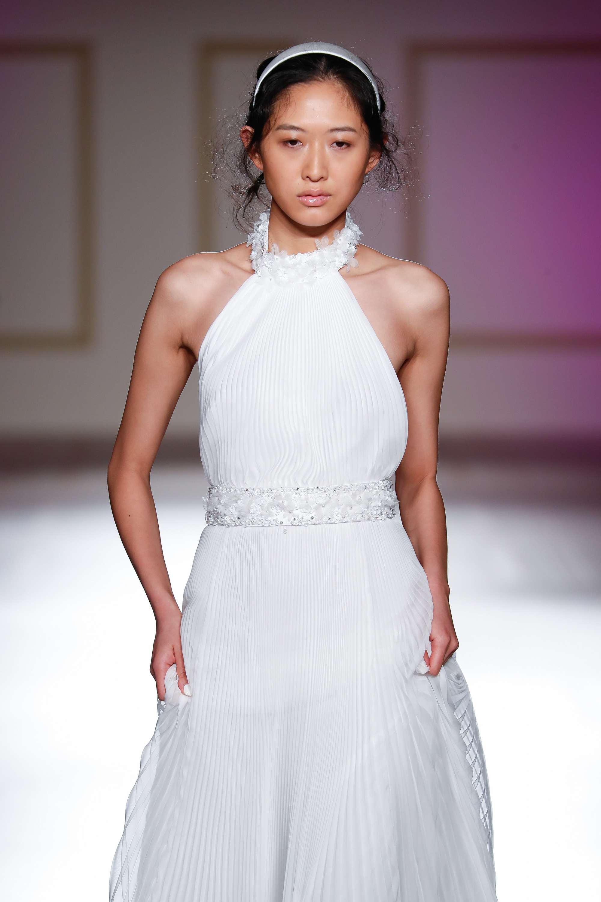 brunette bridal model on the runway with a white headband in her hair