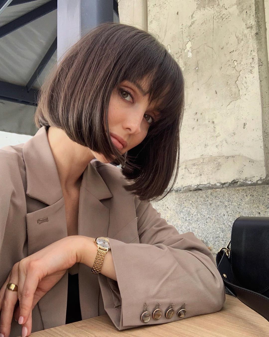 Woman with dark brown short French bob hair with wispy bangs