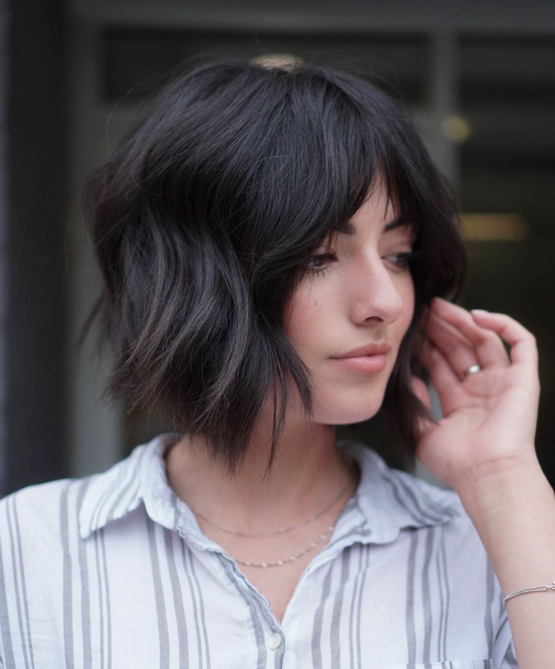 Woman with dark brown textured bob haircut with curtain bangs