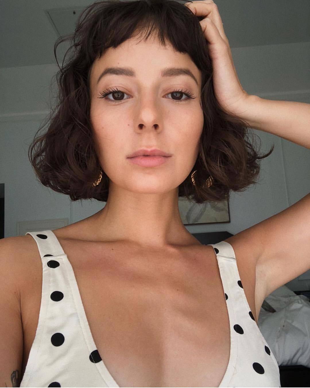 Woman with curly short bob with choppy micro fringe