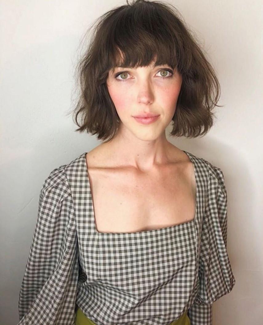 Woman with chestnut brown wavy French bob