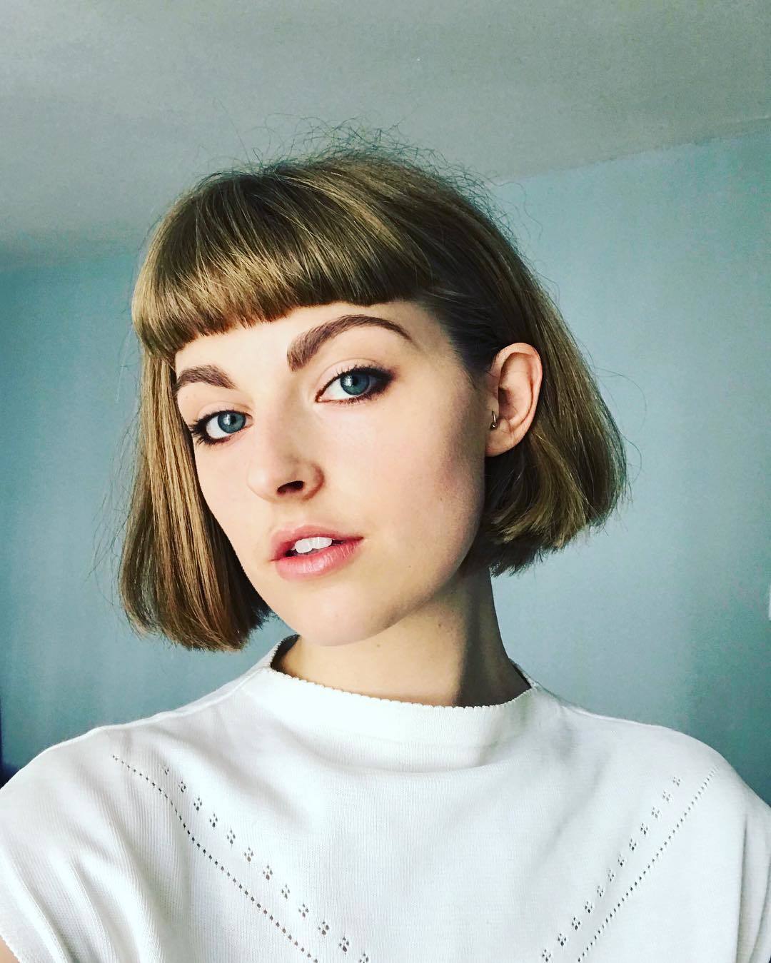 Woman with bronde short sleek bob haircut with micro bangs