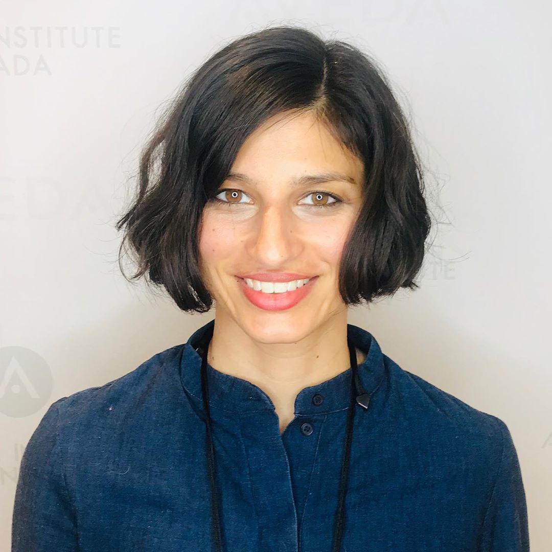 Woman with dark, short side French bob cut