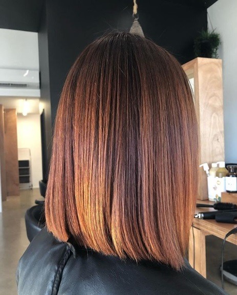 Faits saillants en cuivre: profil latéral d'une femme avec un long bob émoussé de couleur cuivre