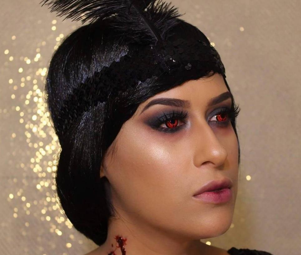 femme au look inspiré de celui d'une fille à clapet, avec un bandeau de plumes et des yeux rouges