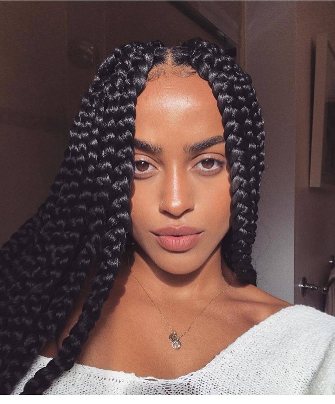 femme avec une coiffure tressée, avec une partie centrale