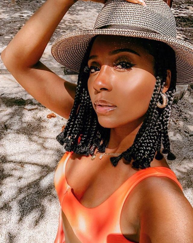 Femme aux tresses de bob portant un chapeau de soleil