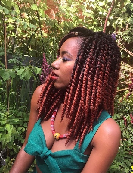 Une femme avec des torsades au crochet de couleur brune et rouge