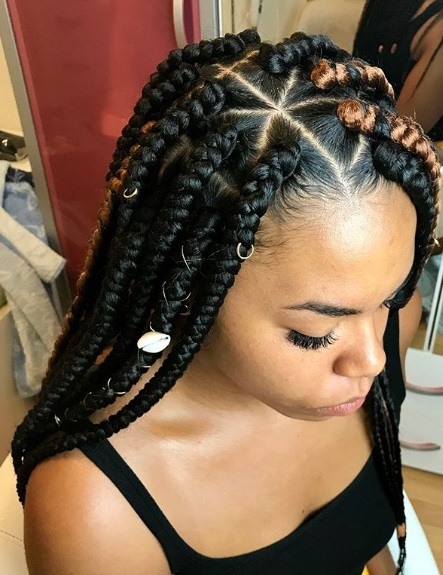 Femme avec des tresses de triangle brunes en boîte avec des bagues de cheveux et des coquillages