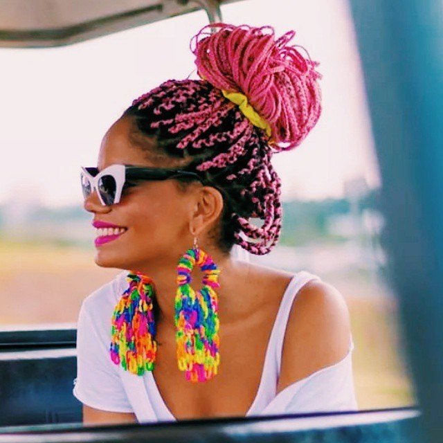 Femme avec des tresses roses en forme de boîte et un chignon haut et désordonné