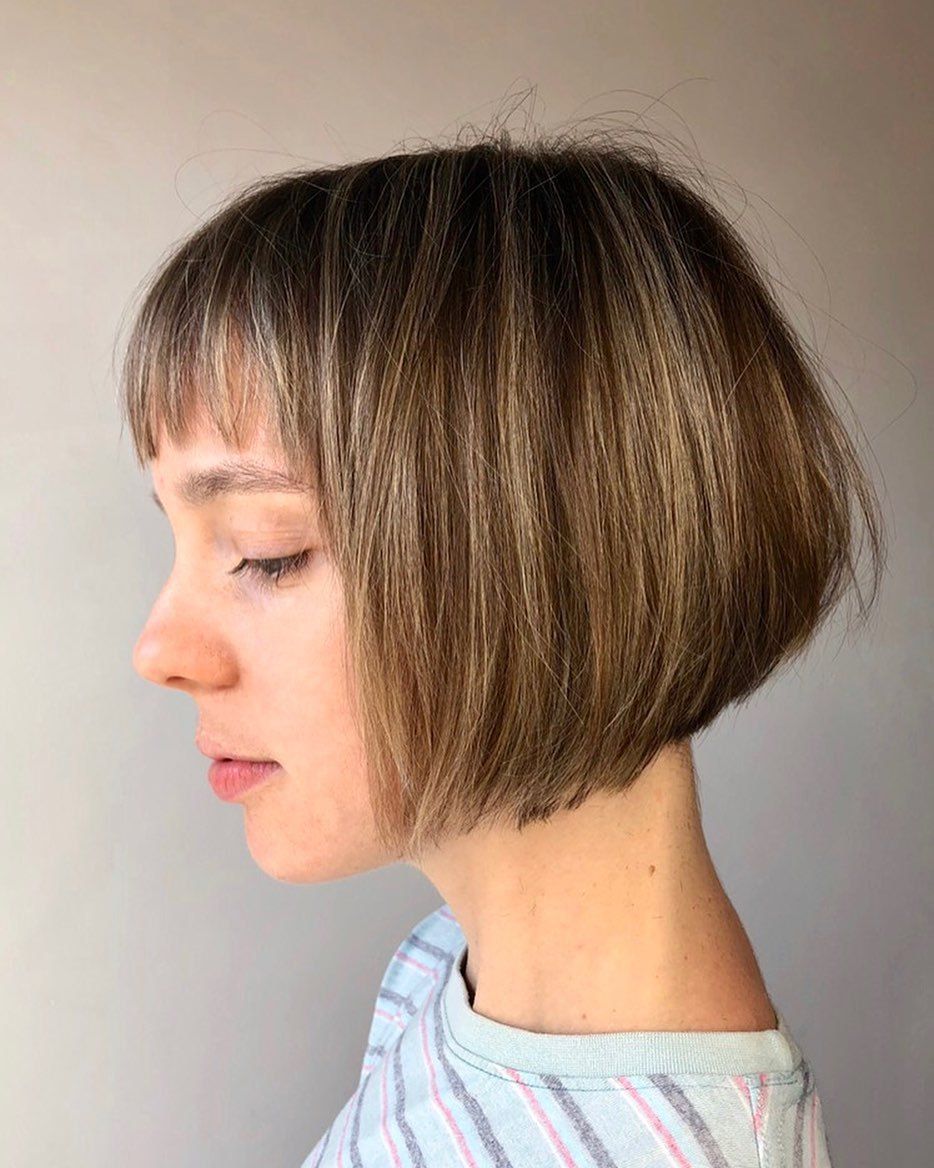 Femme à la bronde inversée avec une courte coiffure et une frange de cheveux