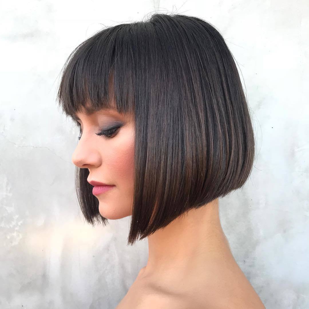Femme au bob court asymétrique avec une frange de plumes