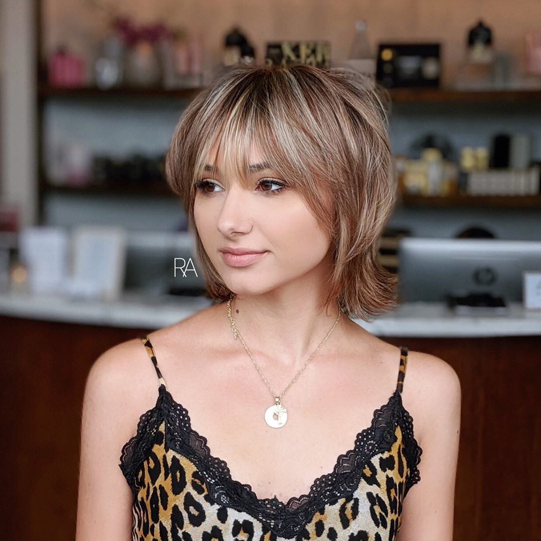 Femme avec un short moderne miel et un bob à poils bruns avec une frange hirsute