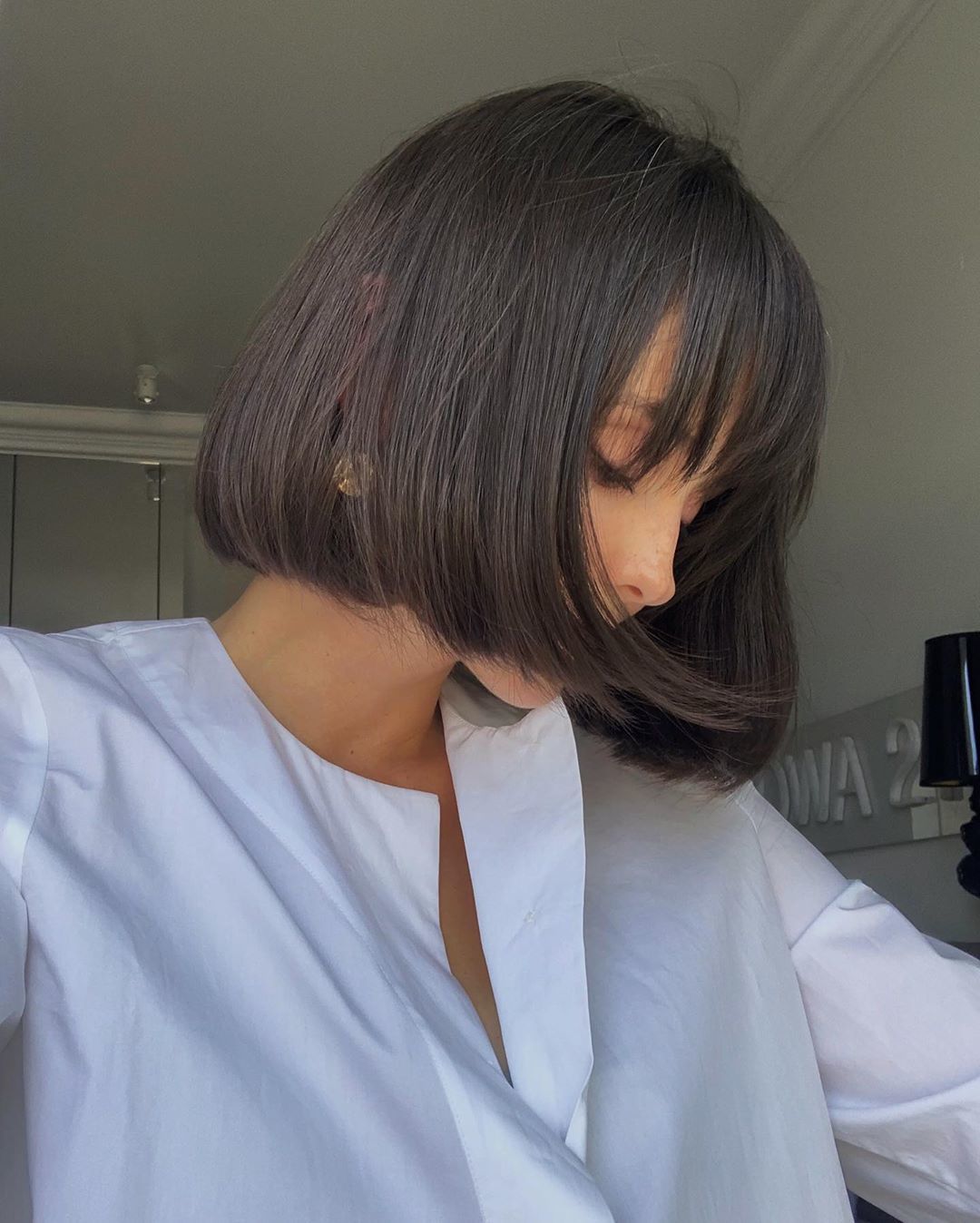 Femme au bob court enroulé avec une frange de cheveux
