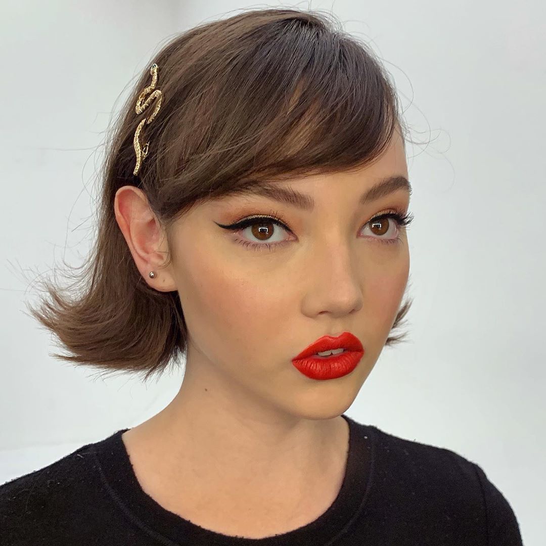 Femme au bob court marron d'inspiration vintage avec une frange de cheveux