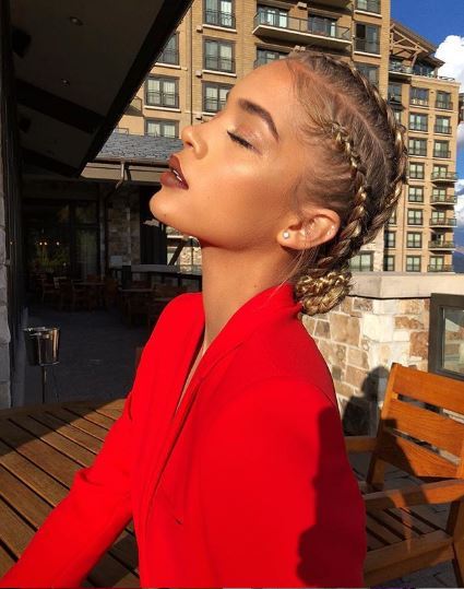 Jasmine Sanders avec des cornrows blonds stylisés en chignon