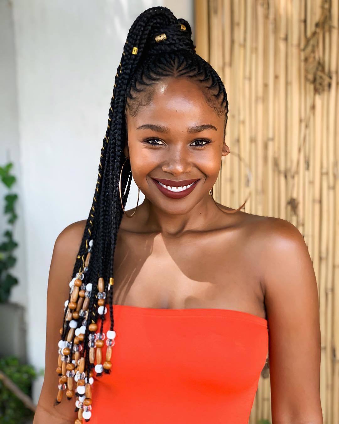 Femme avec une longue queue de cheval en cornrow avec des perles