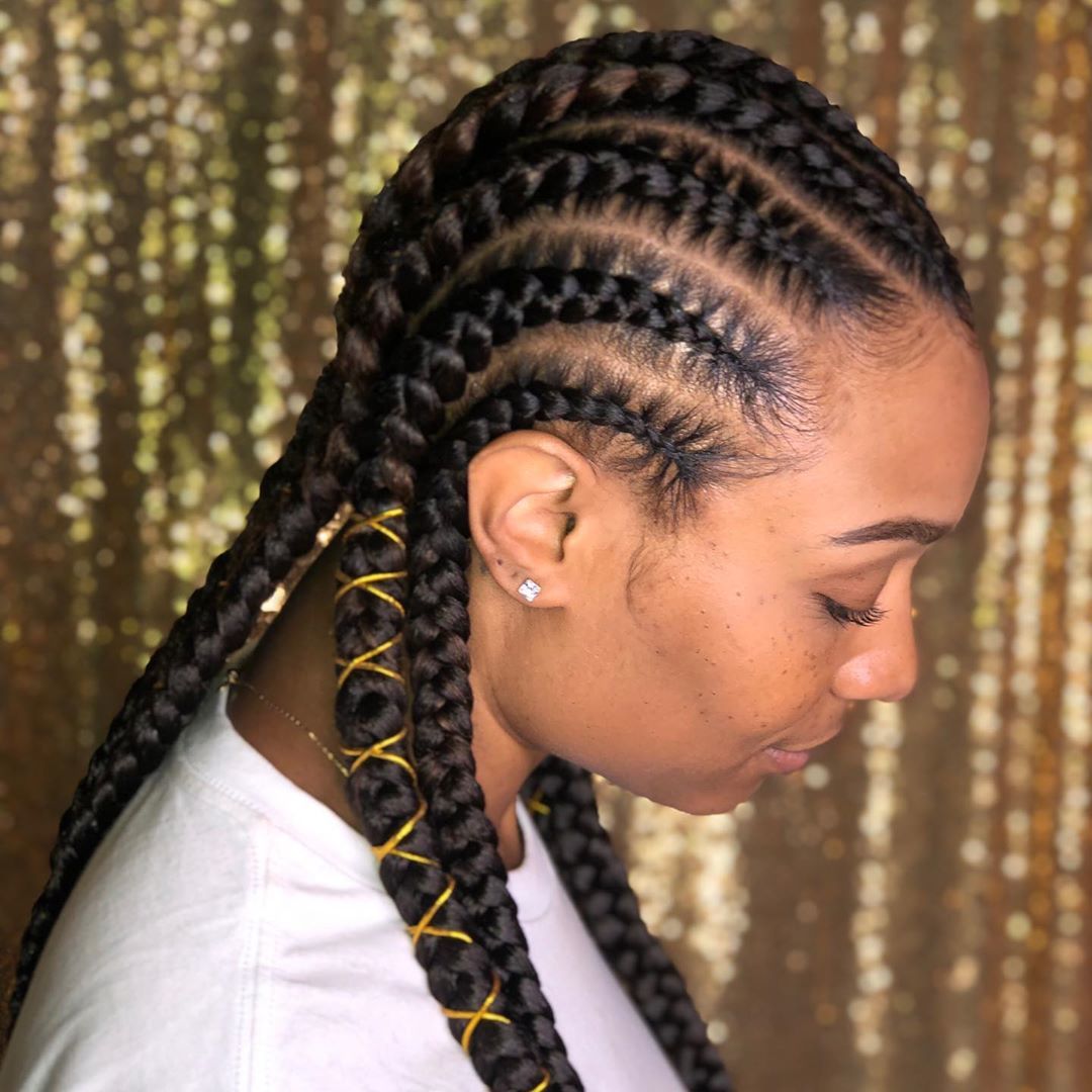 Femme avec du fourrage dans les cornrows avec des détails en fil d'or