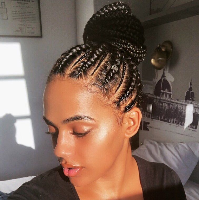 Femme aux cornrows stylisée dans un updo