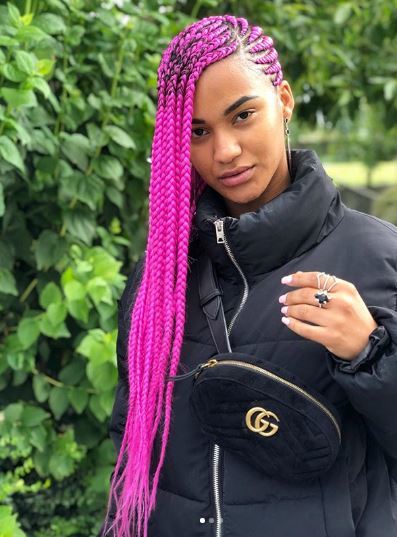 Femme avec de longs cornrows roses sur le côté
