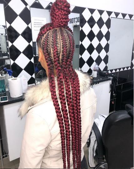Femme avec des cornrows rouges dans un chignon à moitié levé