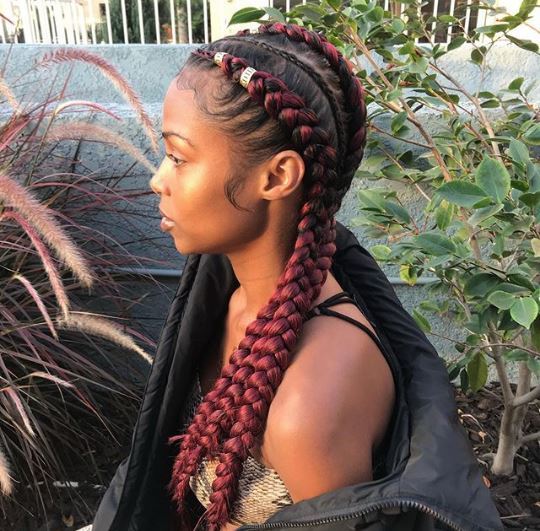 Femme aux tresses de maïs bordeaux avec poignets de cheveux