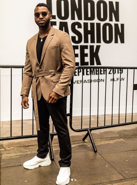 Homme barbu noir à la semaine de la mode de Londres portant une veste de couleur havane