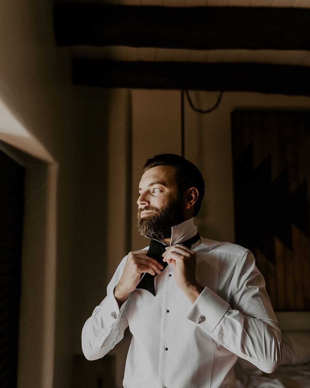 Homme aux cheveux noirs et à la barbe portant un costume