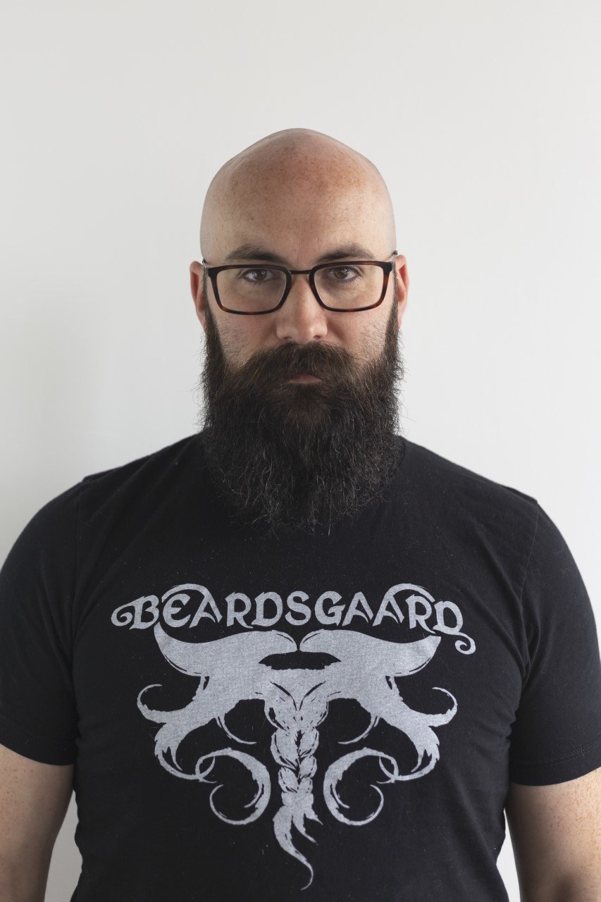 Homme chauve et barbu portant des lunettes