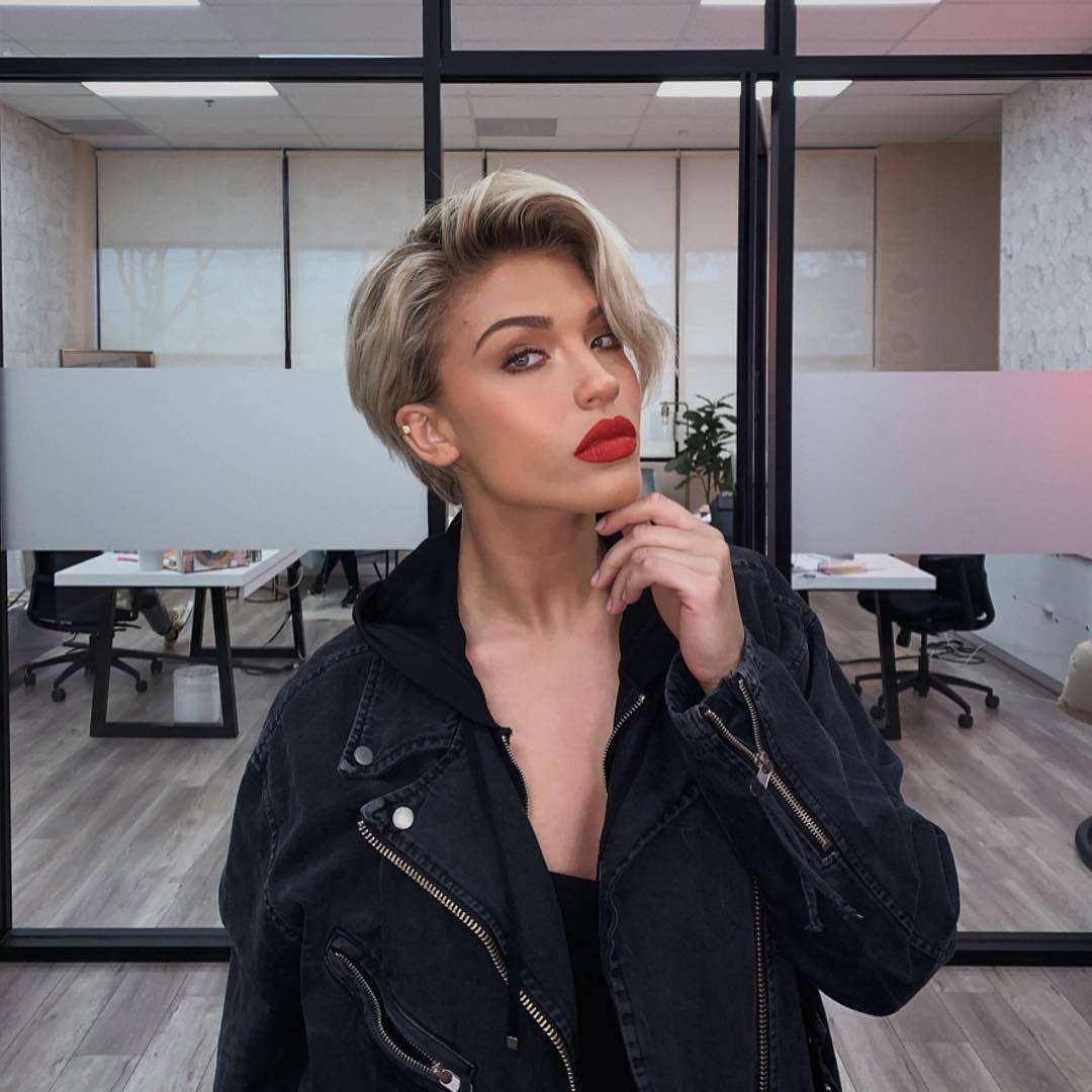 femme au visage carré et à la coupe de cheveux blonde ébouriffée de lutin