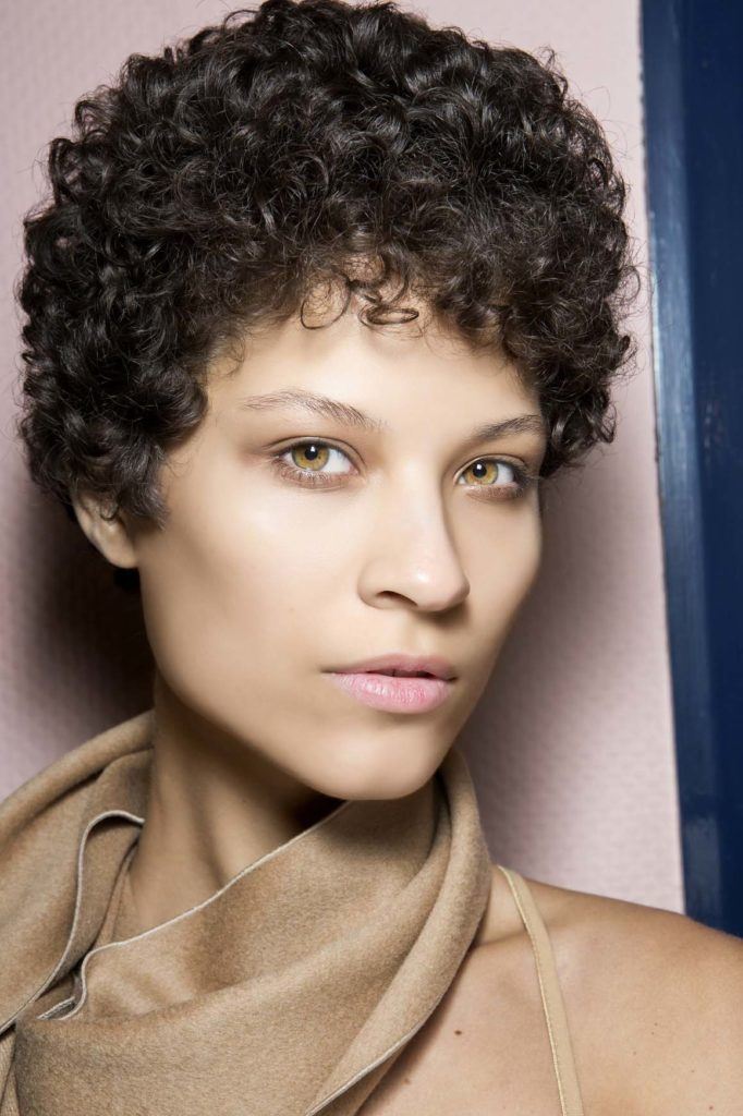 Femme aux cheveux bruns courts et bouclés