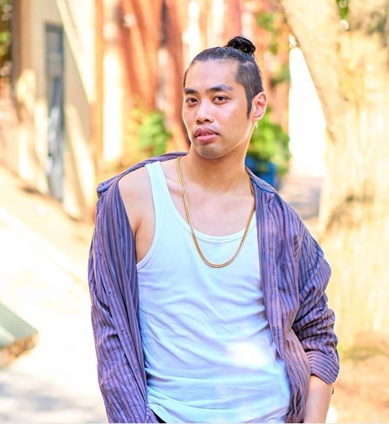 Un homme asiatique avec un petit pain à la coupe 