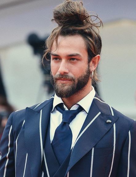 Homme aux cheveux longs bruns en chignon à nœud supérieur 