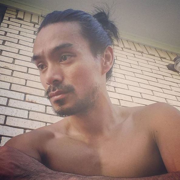 Un homme asiatique, un petit pain : Jeune homme asiatique avec un chignon d'homme haut