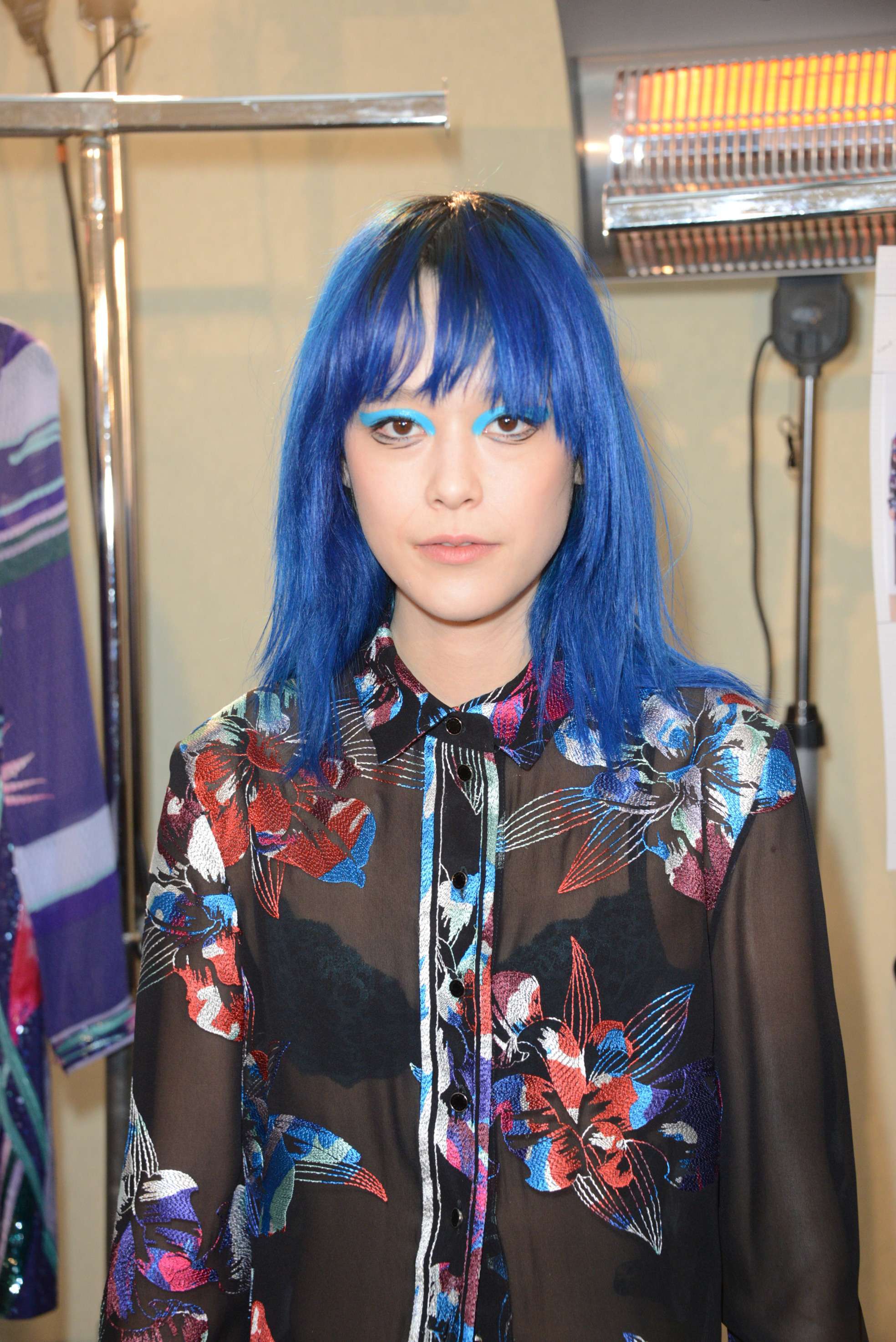femme avec des cheveux bleus de longueur moyenne et une frange 