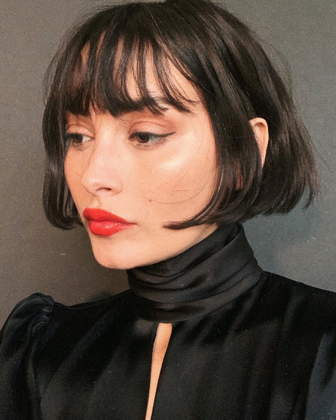 Le mannequin Taylor LaShae avec un carré court brun foncé avec frange.